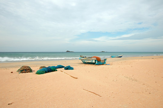 Nets, baskets, and ropes next to fishing boat on Nilaveli beach in Trincomalee Sri Lanka