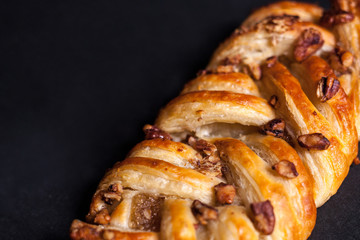 Bun with nuts and jam on a black background