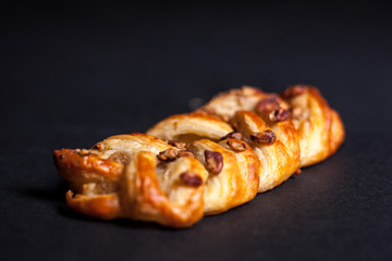 Bun with nuts and jam on a dark background