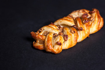 Bun with nuts and jam on a dark background