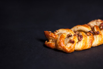 Bun with nuts and jam on a black background