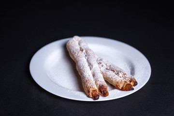 Rolls with cottage cheese on a white plate on a dark background.