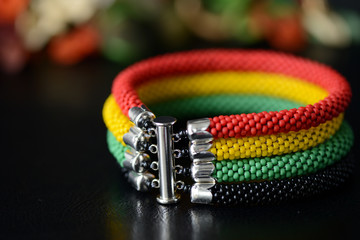 Bead crochet bracelet in Jamaican style on a dark background close up