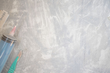 knife, a scalpel, a syringe on a concrete background. concept of sharp objects. save space....