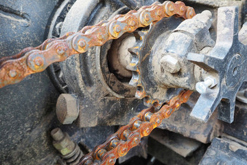 Chain drive. Rusty driving roller chain on the drive sprocket in operation