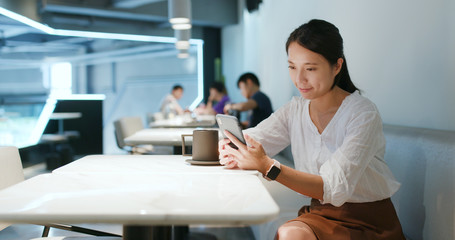 Woman look at mobile phone in the coffee shop