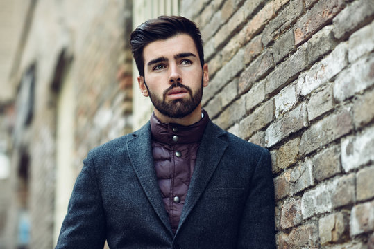 Young Bearded Man In Urban Background Wearing British Elegant Suit In The Street.