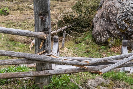 Riesiger Stein Findling auf einer Weide und zerstörtem Holzzaun, Österreich