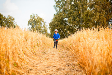 Little boy and girl on a wheat field in the sunlight running, playing enjoying nature. Kid Raising over field and sunset sky background. Children  environment concept