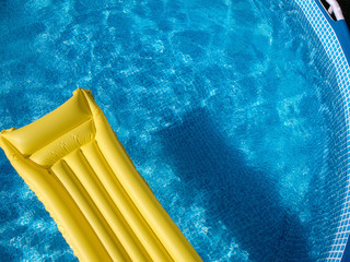 Top view of an inflatable mattress in a backyard swimming pool