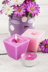 Purple lit candles and pink garden flowers