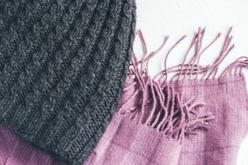 Gray woolen knitted hat and pink scarf on a white background