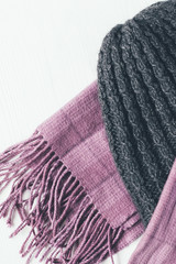 Gray woolen knitted hat and pink scarf on a white background