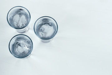 Vodka shots with ice on a white background