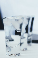 Vodka shots with ice on a white background