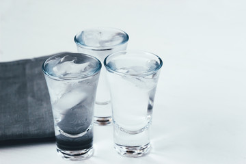 Vodka shots with ice on a white background