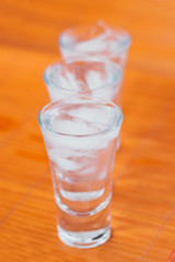 Vodka shots with ice on a white and orange background