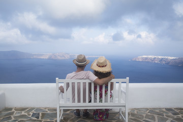 Young couple honeymoon enjoying an amazing view in the most romantic island Santorini, Greece.