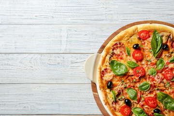 Tasty homemade pizza and space for text on wooden table, top view