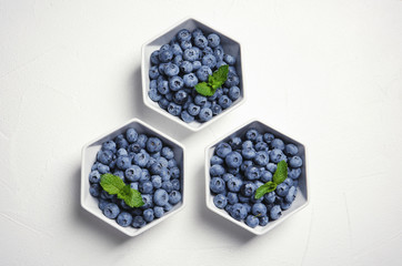 Flat lay composition with fresh blueberries and green leaves on table
