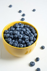 Crockery with juicy and fresh blueberries on white table