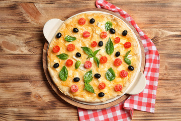 Fresh tasty homemade pizza on wooden background, top view