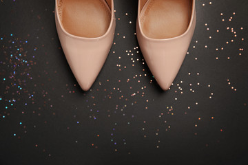 Pair of beautiful shoes and space for text on dark background, top view