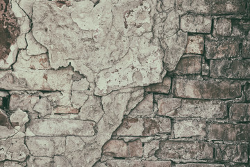 Retro background of old brick wall with fallen off cement plaster