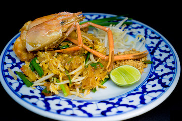 Padthai food from Thailandม  stir-fried rice noodles with Tiger prawn, isolated on black background