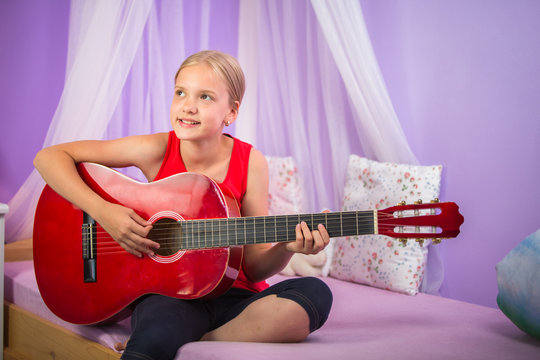 Teenage girl with her guitar in her lovely room&uml;