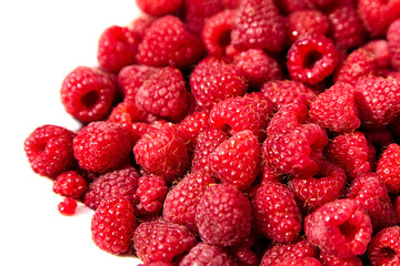 Heap of fresh red ripe raspberries on white background