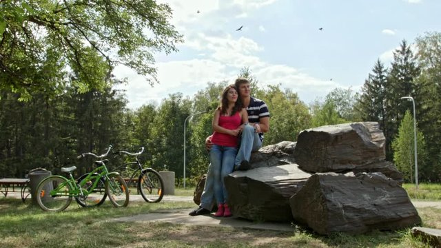 HD Couple sitting on stones in park