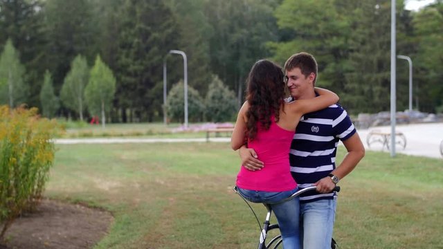 HD A couple is sitting on one bycicle looking at each other and hugs
