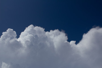 white cumulus clouds move on dark blue sky