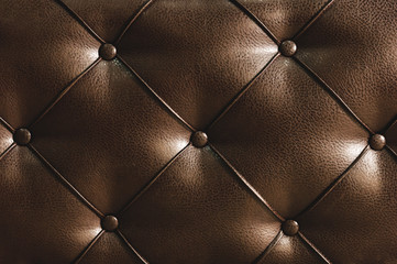 Surface of a rhombic split skin with buttons on the back of the bed. Rhombic patterns of bulk skin brown. Overflowing casing surface