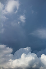 white cumulus clouds on dark blue sky vertical photo