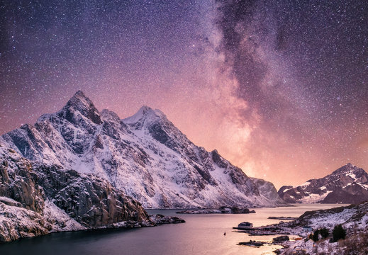 Fototapeta Mountans and reflection on the water surface at the night time. Sea bay and mountains at the night time. Milky way above mountains, Norway. Beautiful natural landscape in the Norway