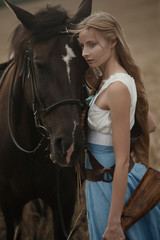 Obraz premium Portrait of a beautiful female cowgirl with shotgun from wild west riding a horse in the outback.