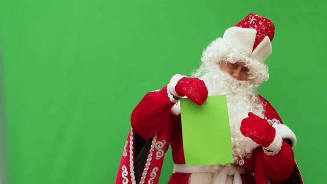 Father Frost holds the form. The New Year's character holds the A4 format model. Green background. An opportunity to insert the design.