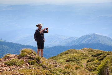Fototapeta na wymiar male hiker trekking and taking pictures in the mountains