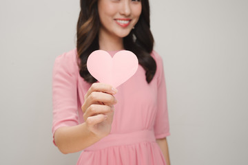 Romantic young woman with paper heart on white background