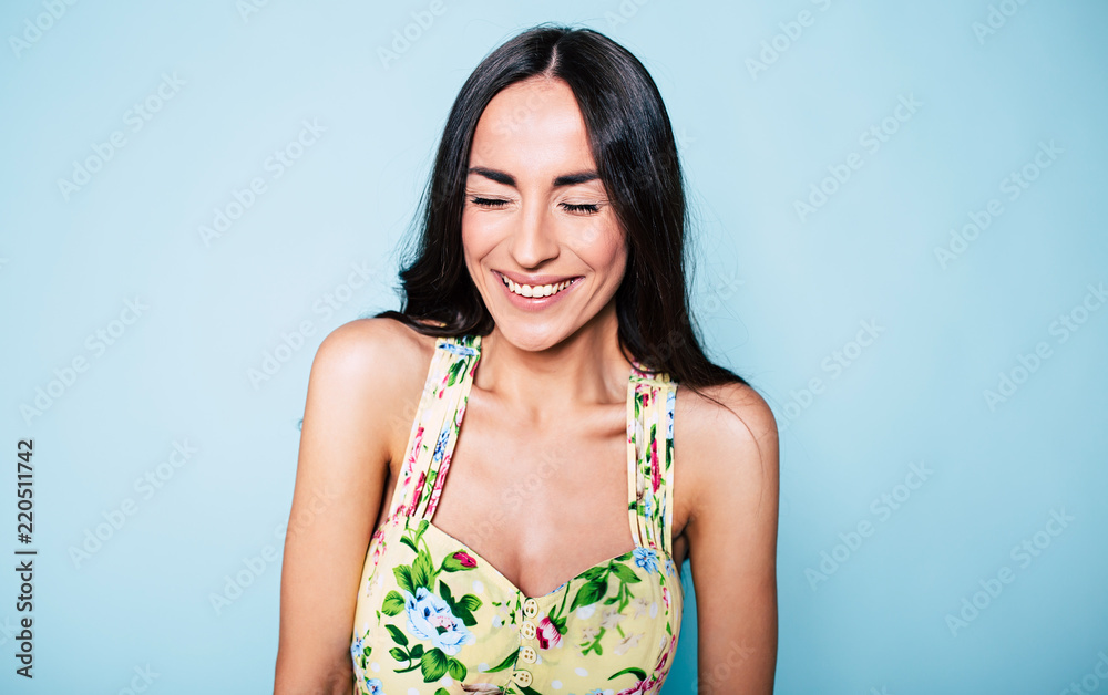 Wall mural cute young smiling gorgeous woman portrait in colorful dress with closed eyes, happy lovely girl