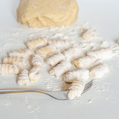 Uncooked homemade potato gnocchi with fork