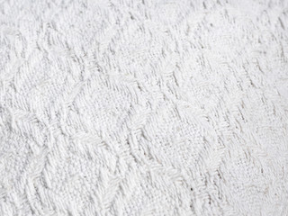 Texture of hand-woven white fabric. Rough threads, prominent textile pattern.