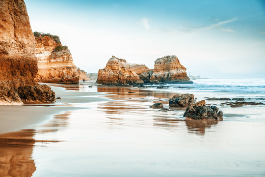 Fototapeta beautiful ocean landscape, the coast of Portugal, the Algarve, rocks on the sandy beach, a popular destination for travel in Europe