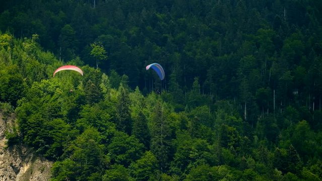 Tandem paragliders flying in the background of Switzerland alps