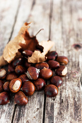 Roast chestnuts in a steel frying pan. Potty with perforated bottom. Wooden background. Vertical photo
