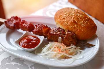skewer kebab lying on a plate with sauce