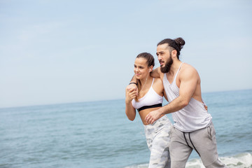 athletic man taking break after workout outdoors walking with his attractive wife on the morning...
