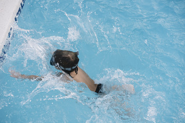 Kid playing and jumping in the pool